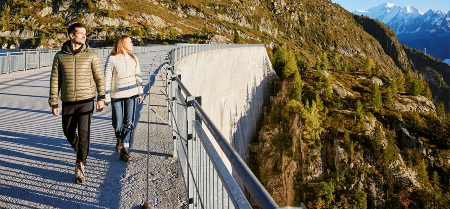 Two people walking on dam during autuum